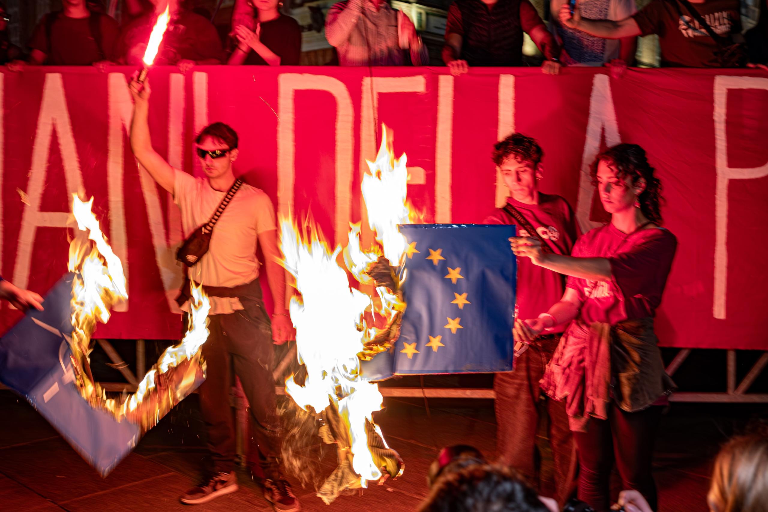 Burning NATO and EU flags. Liberation Day march, Torino.