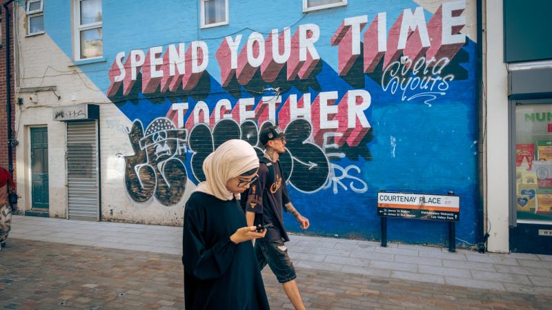 Hijabi and skater. Walthamstow High Street, London.